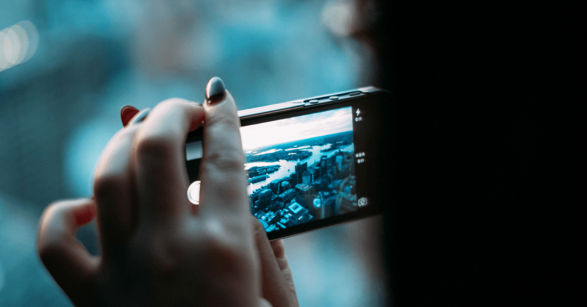 Woman taking a photo out of a window with a mobile phone